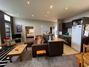 a living room with a couch and a kitchen at All Year Getaway in Twizel