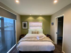 a bedroom with a large bed and a window at All Year Getaway in Twizel