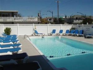 a swimming pool with lounge chairs and a swimming pool at Sunbeach Condo 900 Wesley Avenue Unit 109 in Ocean City +13 photos