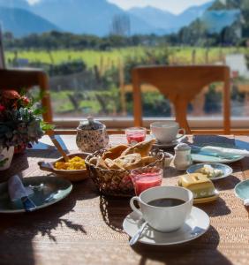 a table with breakfast foods and coffee on it at Hostal Vuelta al Sur in Puelo