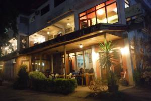 a building with people sitting at tables in front of it at night at Antonio's Pension House in Dipolog