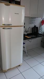 eine weiße Küche mit einem Kühlschrank und einer Theke in der Unterkunft Sun Way 1408 in Ubatuba