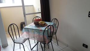 einen Tisch mit Stühlen und eine Obstschale darauf in der Unterkunft Sun Way 1408 in Ubatuba