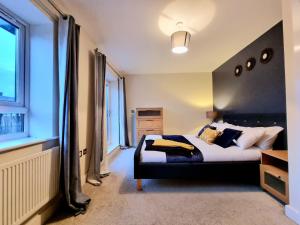 een slaapkamer met een bed en een groot raam bij Luxury 2-Bedroom Service Apartment with Balcony in Manchester