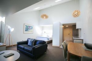 a hotel room with a bed and a couch and a table at Salamanca Inn in Hobart