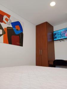 um quarto com uma cama e um quadro na parede em Hotel Posada de Santa Elena em Tunja