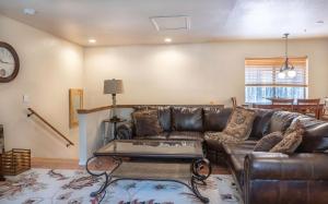 a living room with a leather couch and a table at Grand Canyon 1bd Loft/Suite-Horseback Riding-Shooting-Dogs OK! in Parks