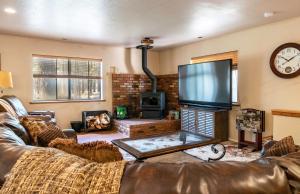 a living room with a couch and a large screen tv at Grand Canyon 1bd Loft/Suite-Horseback Riding-Shooting-Dogs OK! in Parks