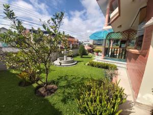 einen Garten mit einem Brunnen in der Mitte eines Gebäudes in der Unterkunft Mirador de Bellavista Riobamba in Riobamba