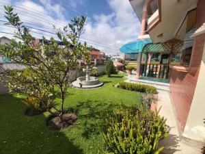 un jardín con una fuente en medio de un edificio en Mirador de Bellavista Riobamba, en Riobamba