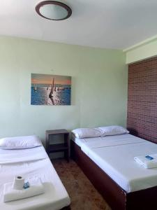Zimmer mit 2 Betten und einem Bild an der Wand in der Unterkunft Antonio's Pension House in Dipolog City