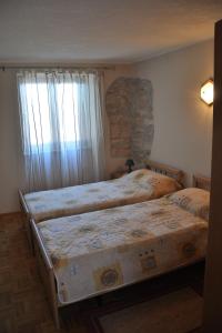 ein Schlafzimmer mit zwei Betten und einem Fenster in der Unterkunft Apartments with a parking space Rakalj, Marcana - 15250 in Krnica