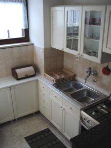 eine Küche mit weißen Schränken und einer Spüle in der Unterkunft Apartments with a parking space Rakalj, Marcana - 15250 in Krnica