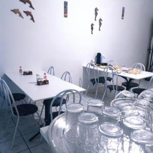 une chambre avec des tables et des chaises avec des lunettes dans l'établissement Pousada Sol e Mar de Pajuçara, à Maceió