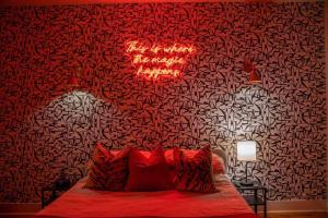 una camera da letto con un letto con cuscini rossi e una parete di Gorgeous Apartment. Montrose / Downtown a Houston