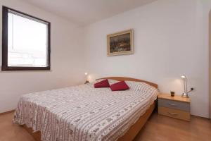 een slaapkamer met een bed met twee rode kussens erop bij Apartments with a parking space Stinjan, Pula - 15256 in Pula