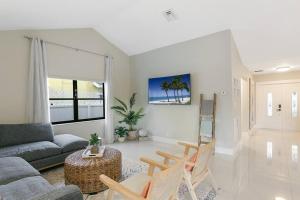 ein Wohnzimmer mit einem Sofa und einem Tisch in der Unterkunft Citrus+Sunshine/Heated Pool/6 min to Beach/Casino in Dania Beach