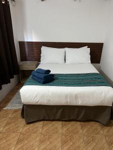 Un dormitorio con una cama con toallas azules. en Ckoinatur Hostel en San Pedro de Atacama