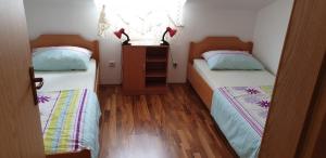two beds in a small room with wooden floors at Apartments with a parking space Pirovac, Sibenik - 15271 in Pirovac