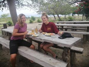 Due ragazze sedute a un tavolo da picnic a mangiare cibo di Pachingo la primavera a San Francisco