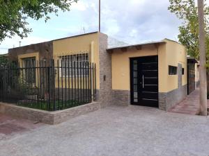 un edificio con una puerta negra y una valla en M & Mendoza en Mendoza