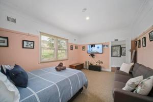 a bedroom with a large bed and a couch at "Mansfield" Cottage Barrington QUALITY HOLIDAY ACCOMMODATION in Barrington