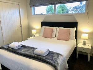 een slaapkamer met een groot bed en 2 handdoeken bij Timeout @ Taupo - Lake Views in Taupo