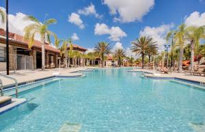 - une piscine dans un complexe avec des palmiers dans l'établissement Beautiful 9 bedroom pool home located in the Solterra Resort! home, à Davenport