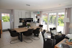 a kitchen and dining room with a wooden table and chairs at Grachtenkate in Greetsiel
