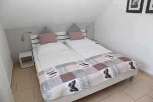 a bedroom with a bed with a blanket on it at Grachtenkate in Greetsiel