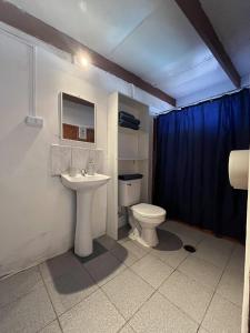uma casa de banho com um WC branco e um lavatório. em Ckoinatur Hostel em San Pedro de Atacama