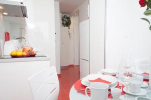 a kitchen with white cabinets and a table with a bowl of fruit at Apartments with WiFi Zagreb - 15314 in Zagreb