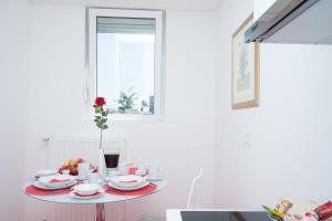 a table with plates and cups and a vase with a flower at Apartments with WiFi Zagreb - 15314 in Zagreb