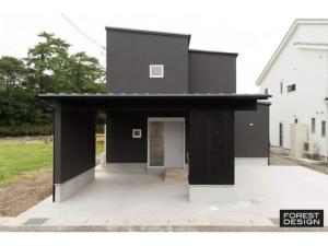 a black house with a door on a patio at Minshuku Kakutani Hitohira - Vacation STAY 16023v in Wada