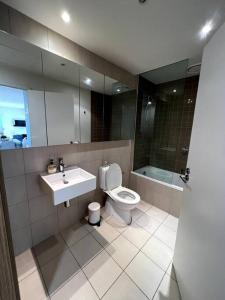 a bathroom with a sink and a toilet and a mirror at Beachside Sunshine Lifestyle-great price-entire aprt at Port Melbourne in Melbourne