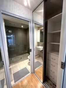 a bathroom with a shower and a toilet and a mirror at Beachside Sunshine Lifestyle-great price-entire aprt at Port Melbourne in Melbourne
