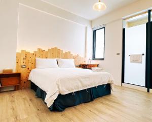 恆春的住宿－山岳民宿，一间卧室配有一张大床和木制床头板