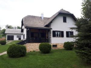 a white house with black windows and a yard at Holiday house with a parking space Poljanak, Plitvice - 15340 in Poljanak +5 photos