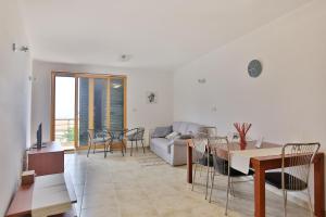 ein Wohnzimmer mit einem Sofa, einem Tisch und Stühlen in der Unterkunft Holiday house with a swimming pool Zadar - Diklo, Zadar - 15336 in Zadar