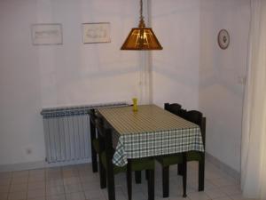 ein Esszimmer mit einem Tisch, Stühlen und einer Lampe in der Unterkunft Apartment Punat 15259b in Punat