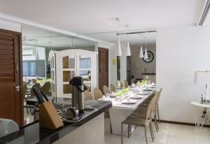 a dining room with a long table with chairs at Apartamento em Barra Bali, Resort de Luxo - Destino BSM 329 in Barra de São Miguel