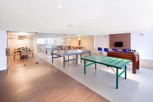 a large room with ping pong tables and chairs at Apartamento em Barra Bali, Resort de Luxo - Destino BSM 329 in Barra de São Miguel