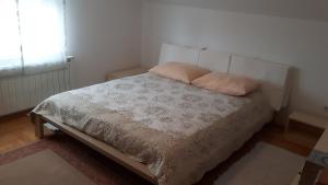 ein Schlafzimmer mit einem Bett mit zwei Kissen darauf in der Unterkunft Apartments with a parking space Zagreb - 15343 in Brezovica
