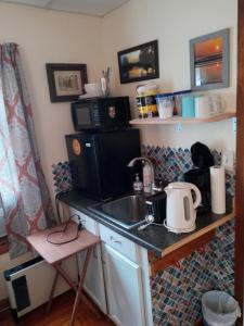 a kitchen with a sink and a microwave at Studio Apartment in Lake George Area. Near Vermont in Granville