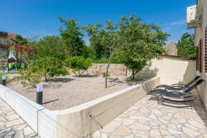 a bench sitting next to a wall with trees at Holiday house with a parking space Zdrelac, Pasman - 15355 in Ždrelac +8 photos