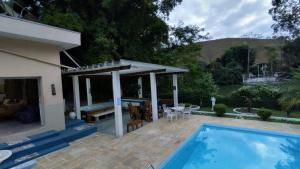 a house with a swimming pool and a patio at Chácara em Guararema Brasil in Guararema