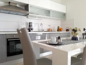 a white kitchen with a white table and chairs at Apartments by the sea Rukavac, Vis - 15369 in Vis