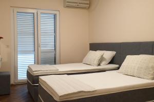 two beds sitting in a room with a window at Apartments and rooms with parking space Hvar - 15378 in Hvar
