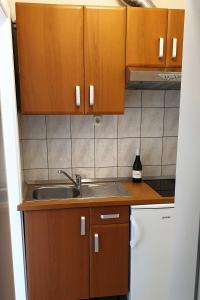 una cocina con armarios de madera y fregadero en Apartments and rooms with parking space Hvar - 15378, en Hvar