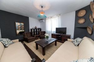 a living room with two couches and a tv at Holiday house with WiFi Novi Vinodolski - 15397 in Novi Vinodolski